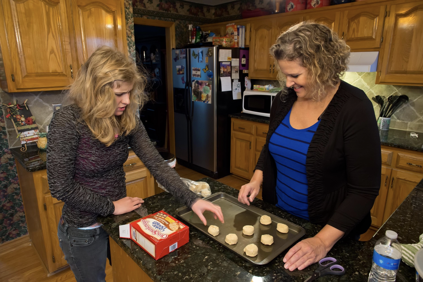 Picture of Mary D. and her family member baking cookies together