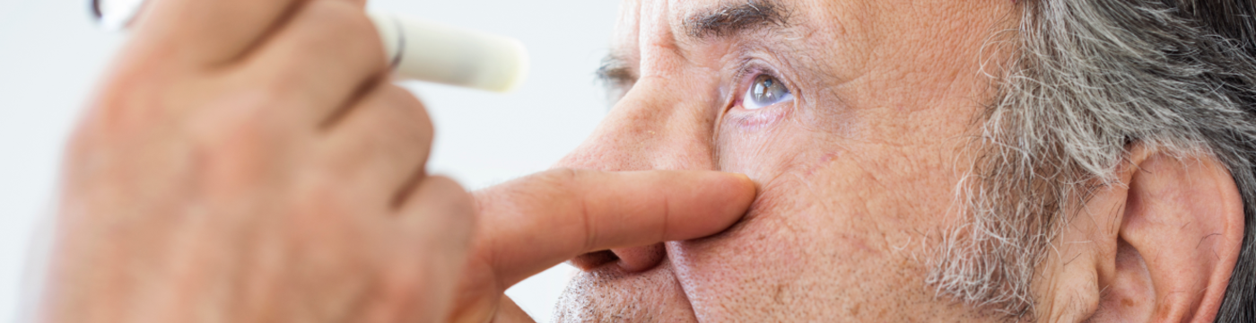 A patient's eye is being observed using a doctor's flashlight